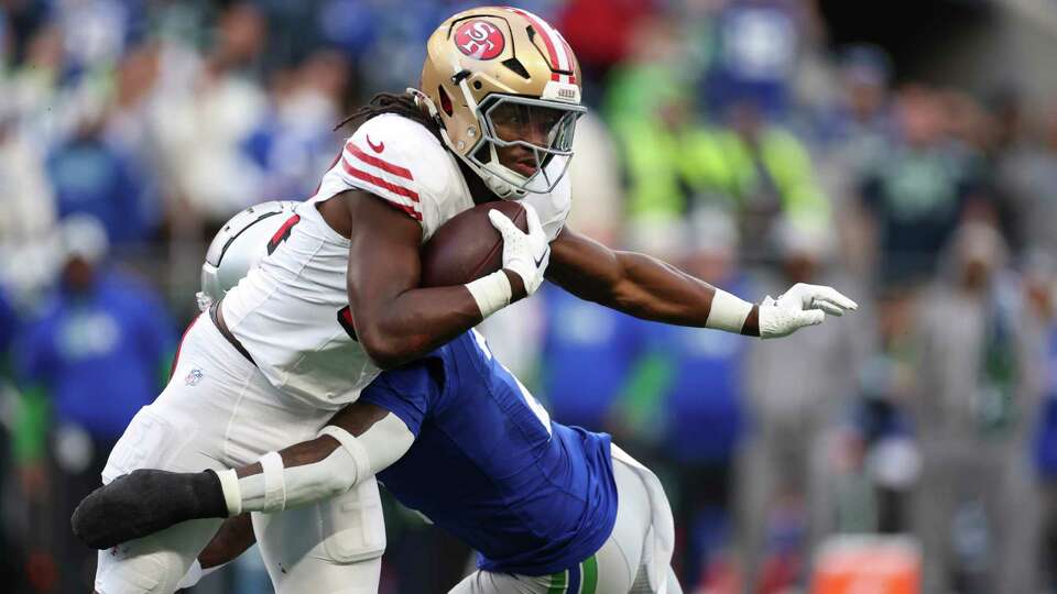 SEATTLE, WASHINGTON - OCTOBER 10: Jordan Mason #24 of the San Francisco 49ers runs the ball and is tackled by Rayshawn Jenkins #2 of the Seattle Seahawks during the first quarter at Lumen Field on October 10, 2024 in Seattle, Washington.