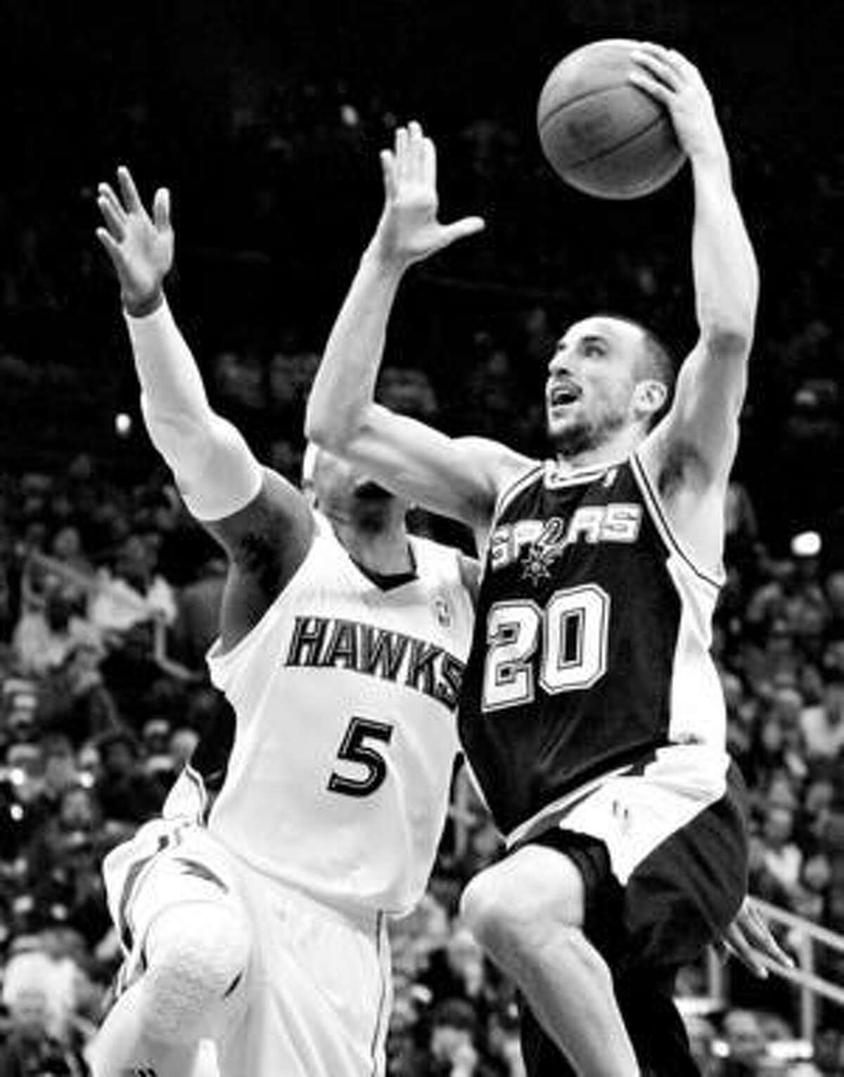 Spurs guard Manu Ginobili puts up a shot in front of Atlanta's Josh Smith during the first half Sunday night.