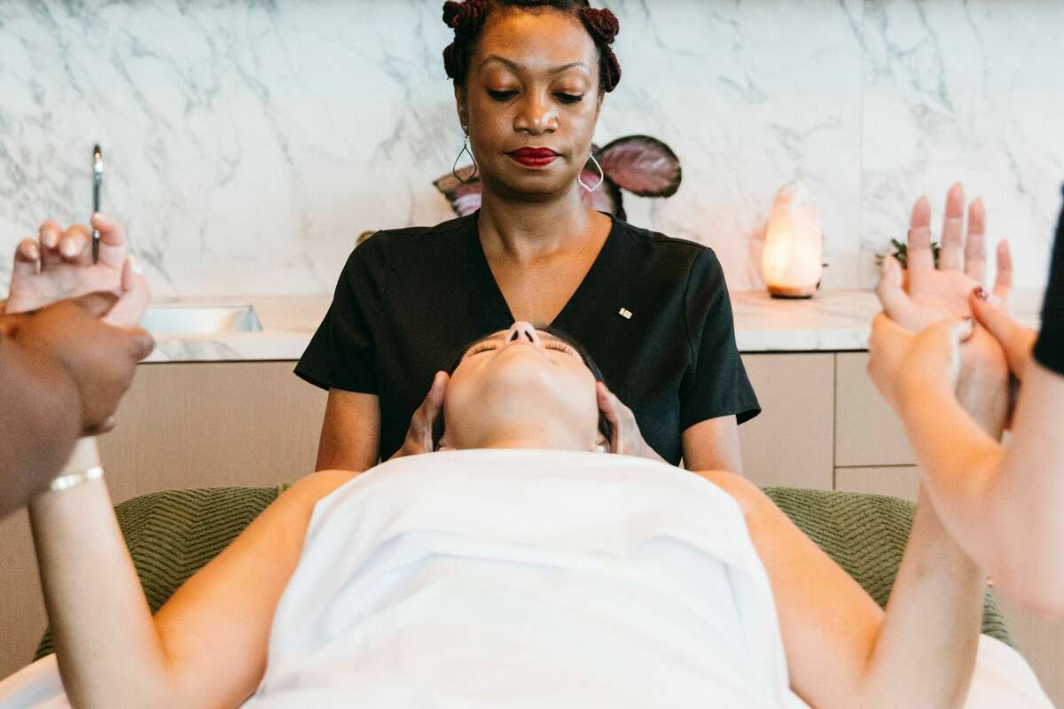 Three masseuses work on a client in the Thompson Spa's Trio Luxe treatment at the Thompson Houston.