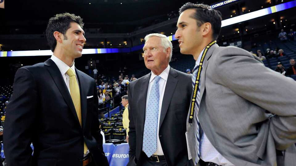 Golden State Warriors general manager Bob Myers, left, speaks with Warrior's executive board member Jerry West and his son and Warrior's scout Jonnie West, at Oracle Arena in Oakland, CA Saturday, February 22, 2014.