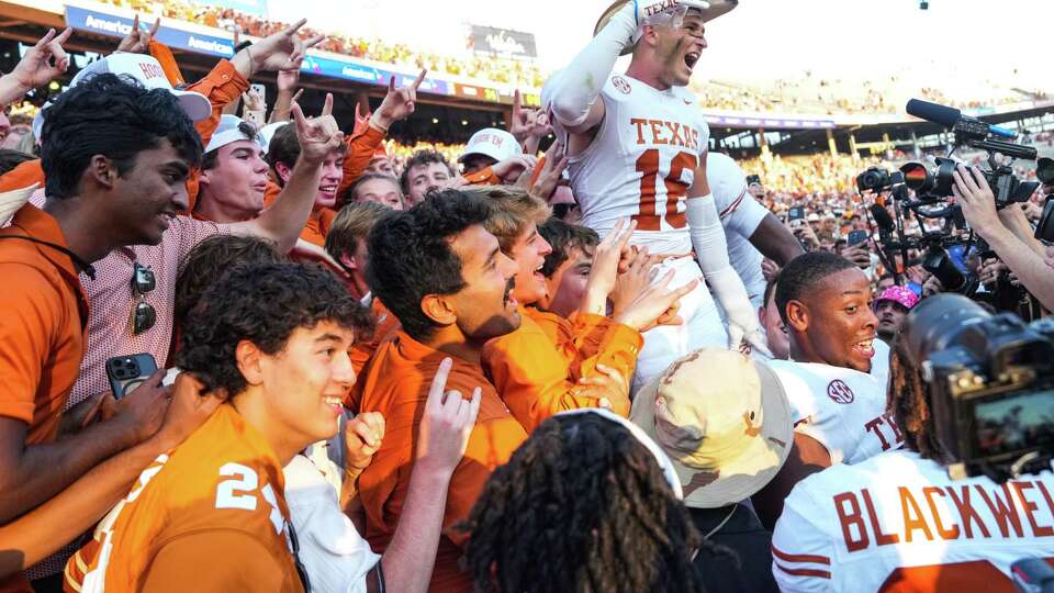 Texas Longhorns defensive back Michael Taaffe (16) celebrates with fans wearing the Golden Hat trophy after defeating Oklahoma 34-3 during an NCAA college football game between Texas and Oklahoma at the Cotton Bowl, Saturday, Oct. 12, 2024, in Dallas.