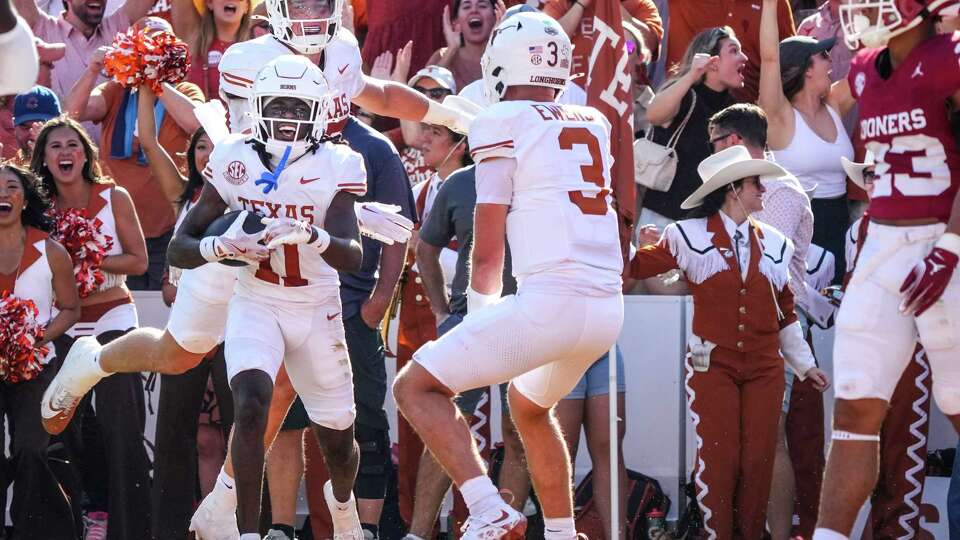 Texas' Silas Bolden reacts toward running back Quintrevion Wisner after recovering his fumble in the end zone for a touchdown during the second quarter of an NCAA college football game at the Cotton Bowl, Saturday, Oct. 12, 2024, in Dallas.