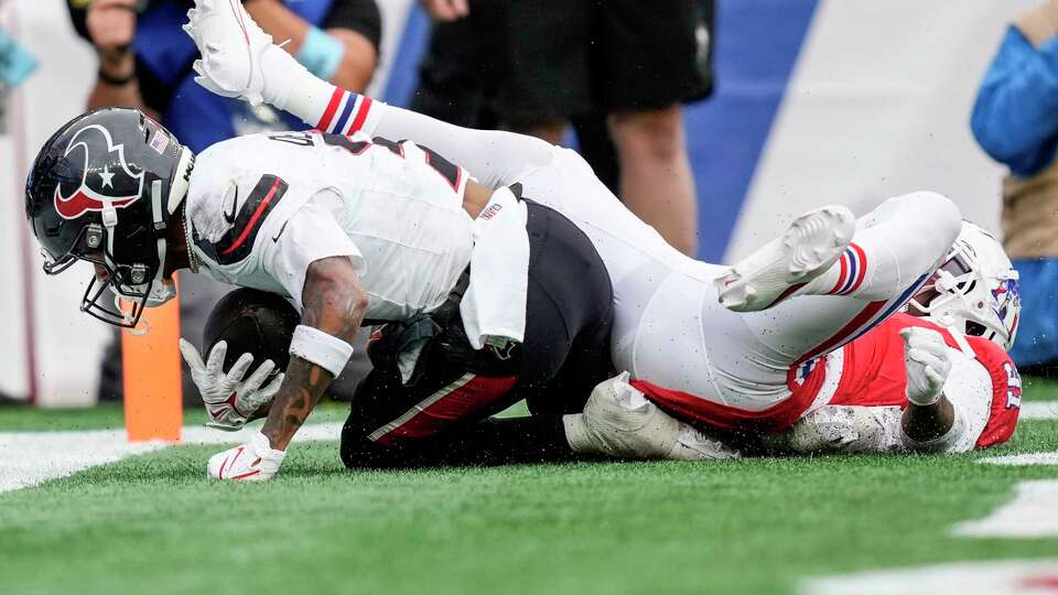 Houston Texans wide receiver Tank Dell (3) comes down with a 2-yard touchdown reception against New England Patriots cornerback Jonathan Jones (31) during the first half of an NFL football game Sunday, Oct. 13, 2024, in Foxborough, Mass.