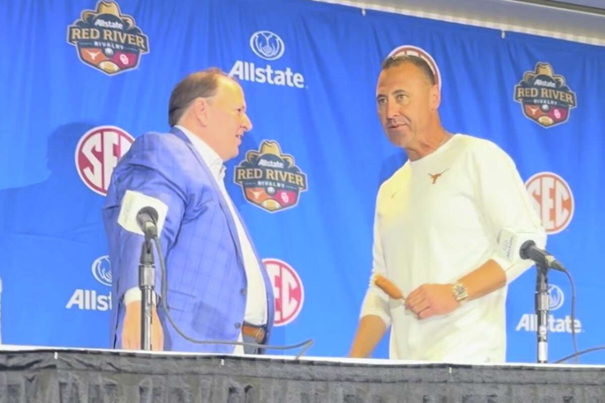 Texas head coach Steve Sarkisian carries a Fletcher's corny dog into his postgame press conference following 343-3 defeat of Oklahoma on Saturday, Oct. 12. (one-time use only) 