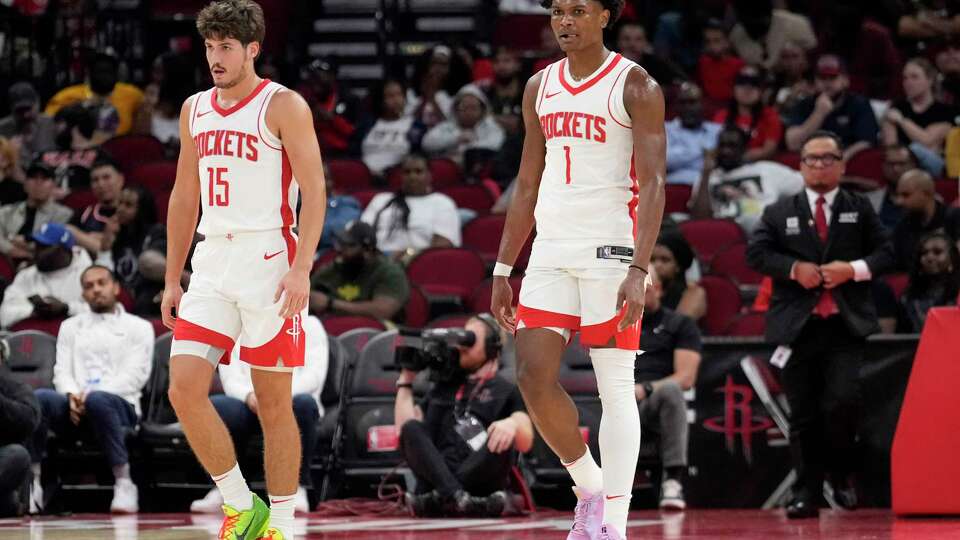 Houston Rockets guard Reed Sheppard (15) and forward Amen Thompson (1) walk up the court during the second half on a preseason NBA basketball game on Tuesday, Oct. 15, 2024 in Houston.