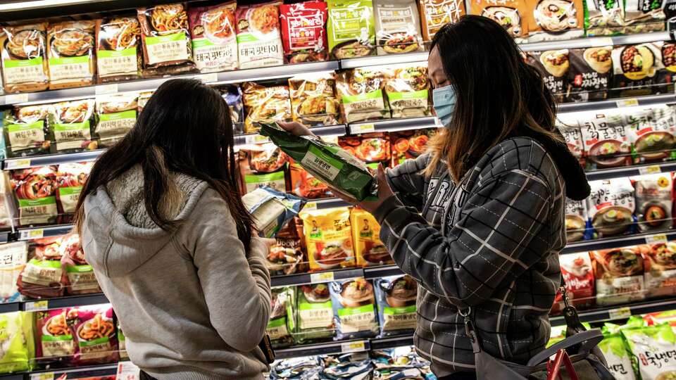 Micky Lee, right, and niece Katelyn Loi shop for noodles at H Mart during its long-anticipated grand opening in the Ingleside Heights neighborhood of San Francisco, California Wednesday, April 21, 2021.