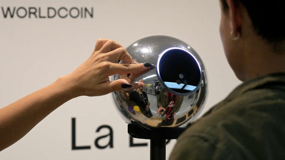 A man has his iris scanned with an orb, a biometric data scanning device, in exchange for the Worldcoin cryptocurrency in Buenos Aires on March 22, 2024. In recent months, hundreds of thousands of Argentines have stood in front of a Worldcoin orb to scan the iris of their eyes in inflation-hit Argentina, where recent tightening delivered the coup de grace. The Worldcoin cryptocurrency, with a verification system based on iris recognition and launched in July 2023 by OpenAI CEO Sam Altman, is being closely watched by regulators in several countries due to data protection concerns. (Photo by JUAN MABROMATA / AFP) (Photo by JUAN MABROMATA/AFP via Getty Images)