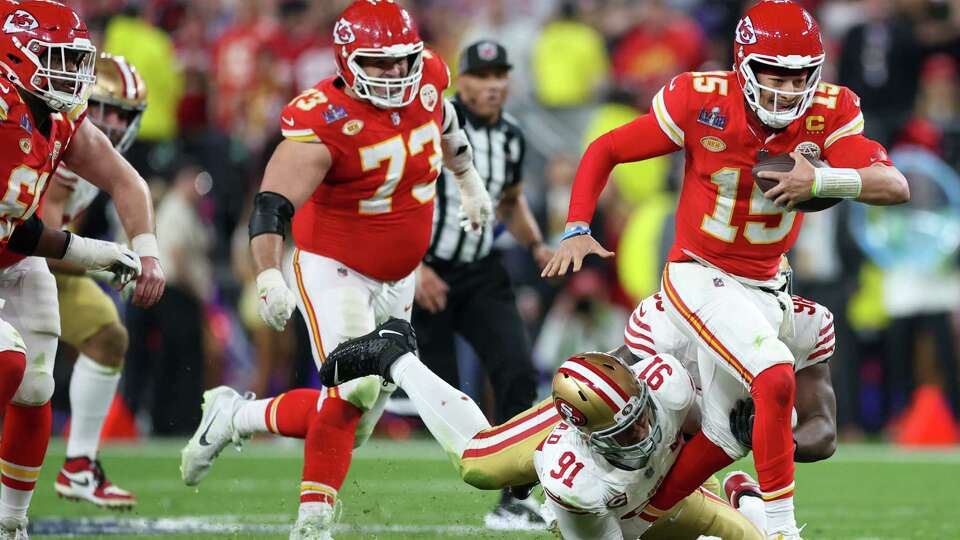 Kansas City Chiefs’ quarterback Patrick Mahomes, 15, tries to elude a San Francisco 49ers’ defensive end Arik Armstead, 91, tackle in the fourth quarter during Super Bowl LVIII at Allegiant Stadium in Las Vegas, NV, on Sunday, Feb. 11, 2024.