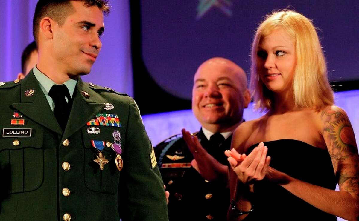 U.S. Army Sgt. Joseph Lollino looks over at his wife Ashley after receiving the Distinguished Service Cross and Purple Heart medals during a ceremony at the start of Army's medical symposium at the Convention Center Monday.
