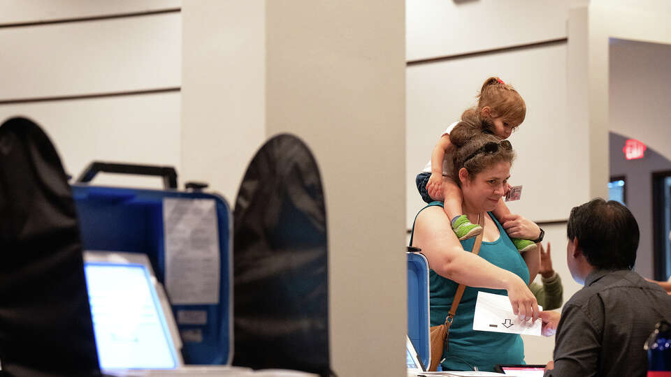 Talya Arbisser holds carries her daughter Dara Gluskin, 1, both of Bellaire, TX as she prepares to vote at a polling location at Houston Community College in Houston, TX on October 24, 2024.