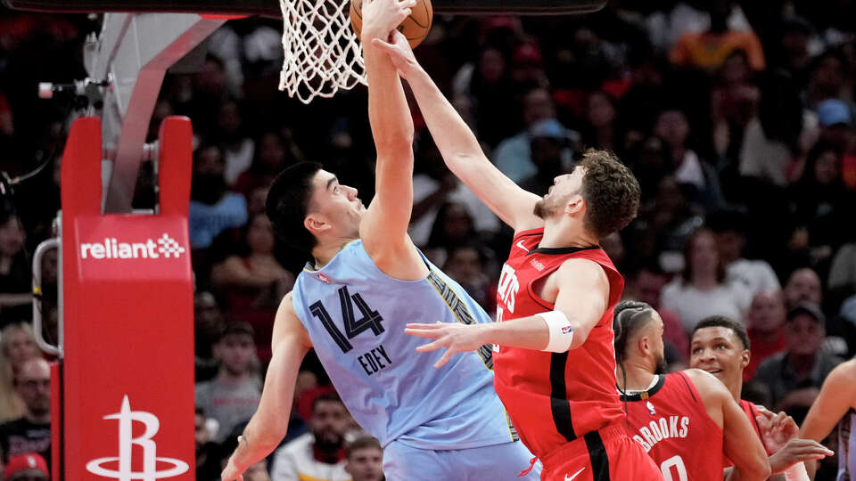 Memphis Grizzlies center Zach Edey (14) and Houston Rockets center Alperen Sengun compete for a rebound during the first half of an NBA basketball game Friday, Oct. 25, 2024, in Houston. (AP Photo/Eric Christian Smith)