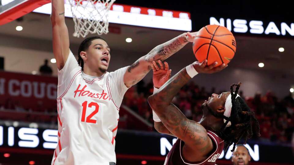 Houston center Jacob McFarland (12) attempts to break up a shot-attempt by Texas A&M guard Manny Obaseki, front right, during the first half of an NCAA college basketball game Sunday, Oct. 27, 2024, in Houston. (AP Photo/Michael Wyke)