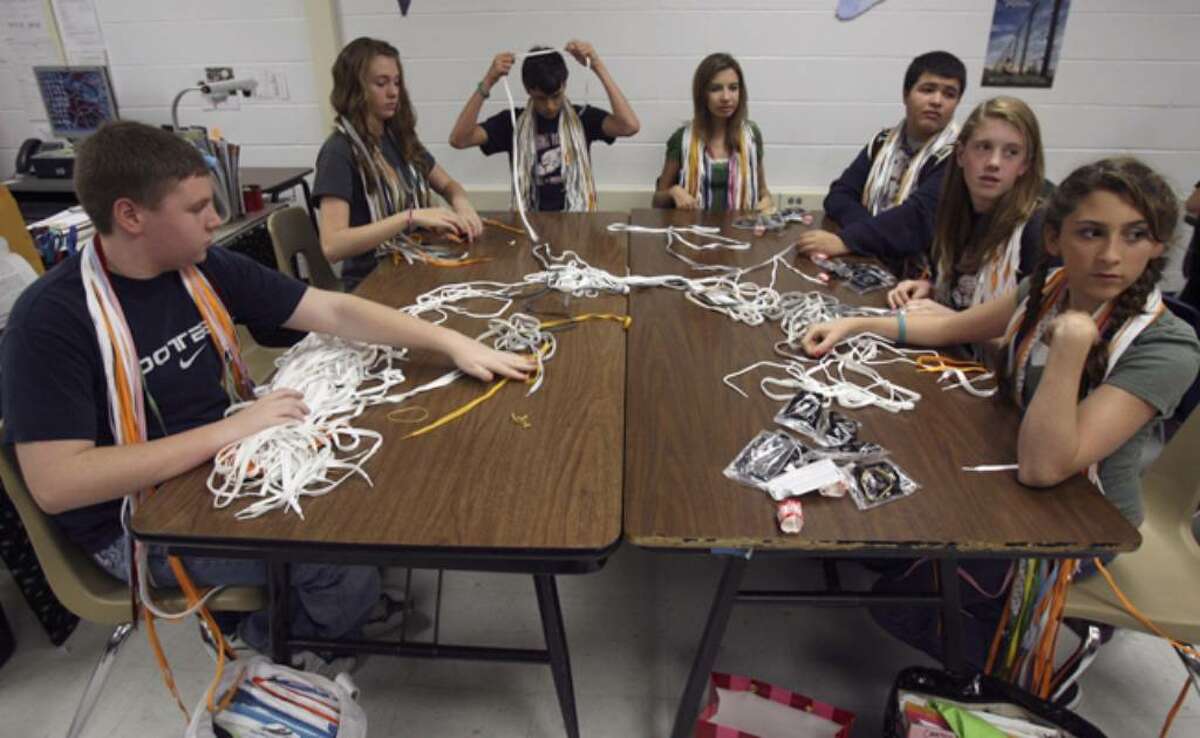 Smithson Valley students separate shoelaces during class Thursday. They've collected more than 3,000, with a goal of 18,550, the number of people killed in a week at Auschwitz during the Holocaust.