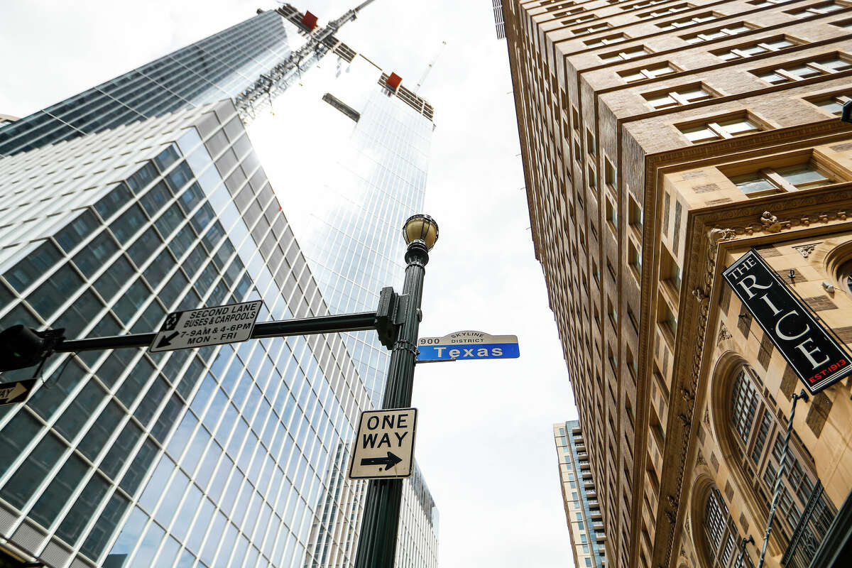 Exterior of the 47-story Texas Tower office building at 845 Texas Ave, across the street from the Rice Lofts, right, in downtown Houston after a topping out ceremony, Monday, March 22, 2021. The building, designed by Pelli Clarke Pelli, is a development of Hines and Ivanhoé Cambridge. Hines hoisted an evergreen tree to signal completion of the framing of the structure and wish luck for the future of the building project and its eventual occupants.