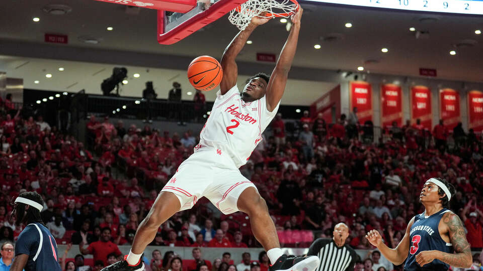 Houston Cougars center Cedric Lath (2) dunks as a takes a fast break past Jackson State Tigers guard Jayme Mitchell Jr. (3) during the first half of an NCAA college basketball game on Monday, Nov. 4, 2024, in Houston.