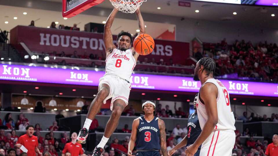 Houston Cougars guard Mylik Wilson (8) dunks as he drives to the basket past Jackson State Tigers guard Jayme Mitchell Jr. (3) during the second half of an NCAA college basketball game on Monday, Nov. 4, 2024, in Houston.