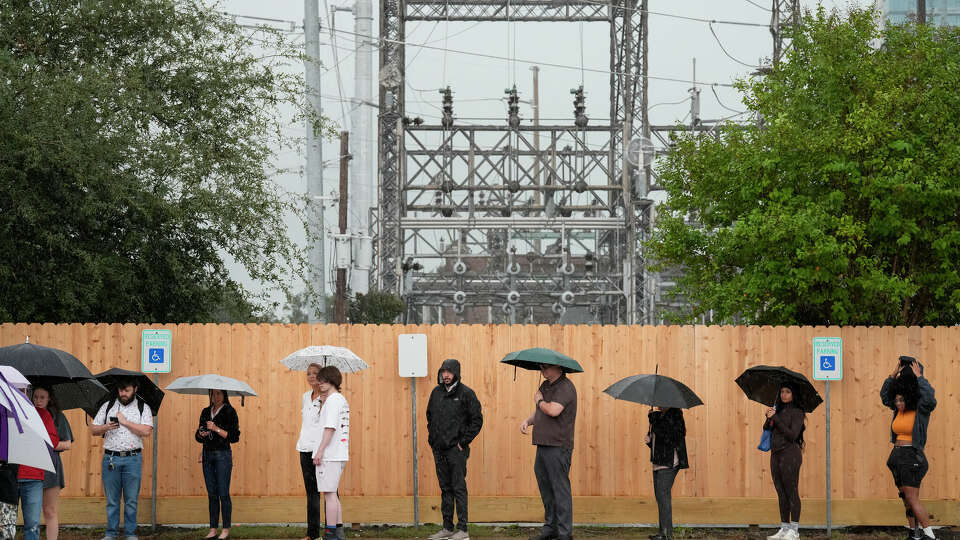 Rain pours down while voters are waiting in line to cast their vote on Election Day Tuesday, Nov. 5, 2024 at West Gray Multiservice Center in Houston.