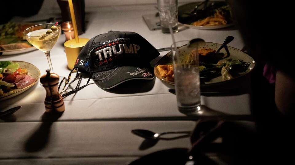 A Trump-themed hat rests on a table as attendees enjoy dinner during the San Francisco Republicans watch party at American Bites on Election Day in San Francisco on Tuesday, Nov. 5, 2024.