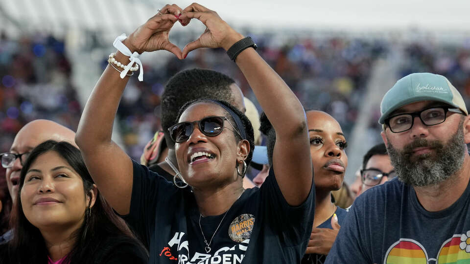 Sharon Denise Russ makes a heart sign to the music by DJ Tryfe during the pre-program at a Vice President Kamala Harris rally Friday, Oct. 25, 2024 at Shell Energy Stadium in Houston.