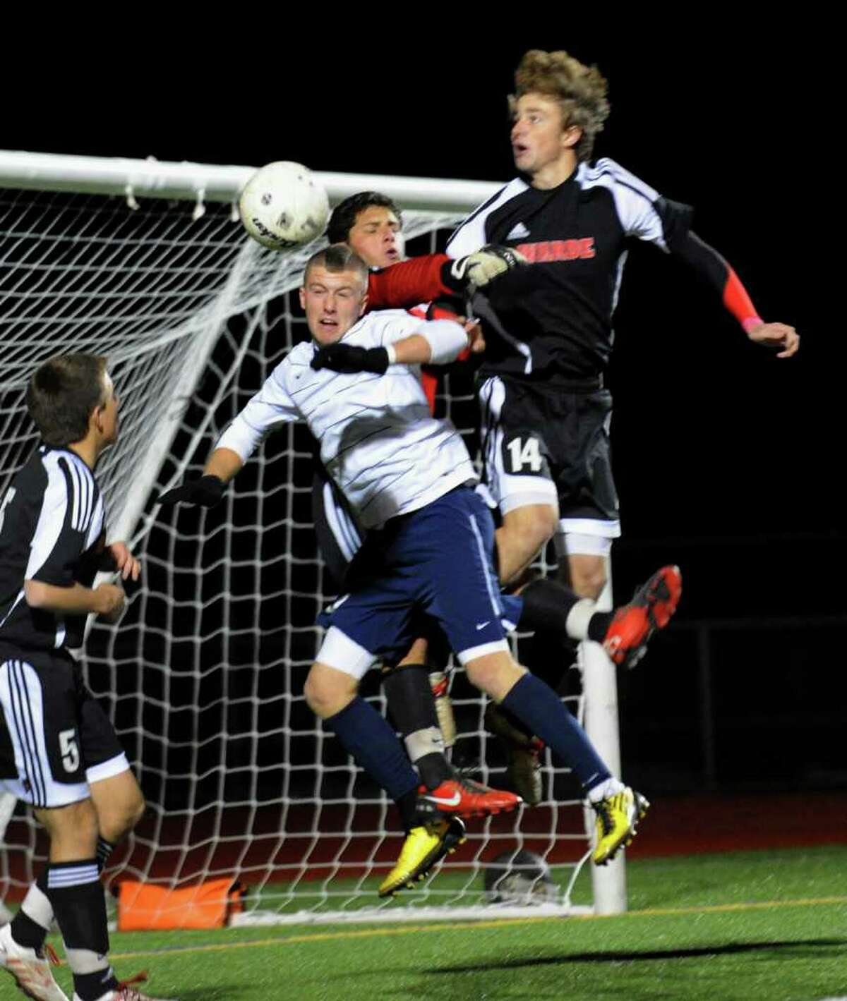 Staples #9 Brendan Lesch tries to head the ball in for a goal but is hampered by Fairfield Warde goalie Dylan Strachen, top center, and #14 Connor Gavey, top right, during FCIAC Championship boys soccer in Norwalk, Conn. on Wednesday November 03, 2010.
