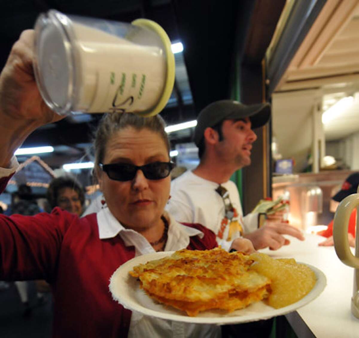 Kathy Ingram adds salt to her kartoffelpuffers. The German potato pancake, with a side of applesauce, is a New Braunfels tradition during the 10 days of Wurstfest.