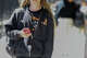 A student carries their cell phone after unlocking the pouch that secures it from use during the school day.