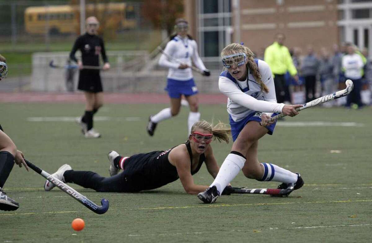 Darien High School captain Sam Johnston fires a shot on the Fairfield Warde goal during the Blue Wave's 4-0 FCIAC drubbing over the Mustangs of Fairfield. Looking in on the play is Fairfield Warde's Stacey Dileo. 11/5/10