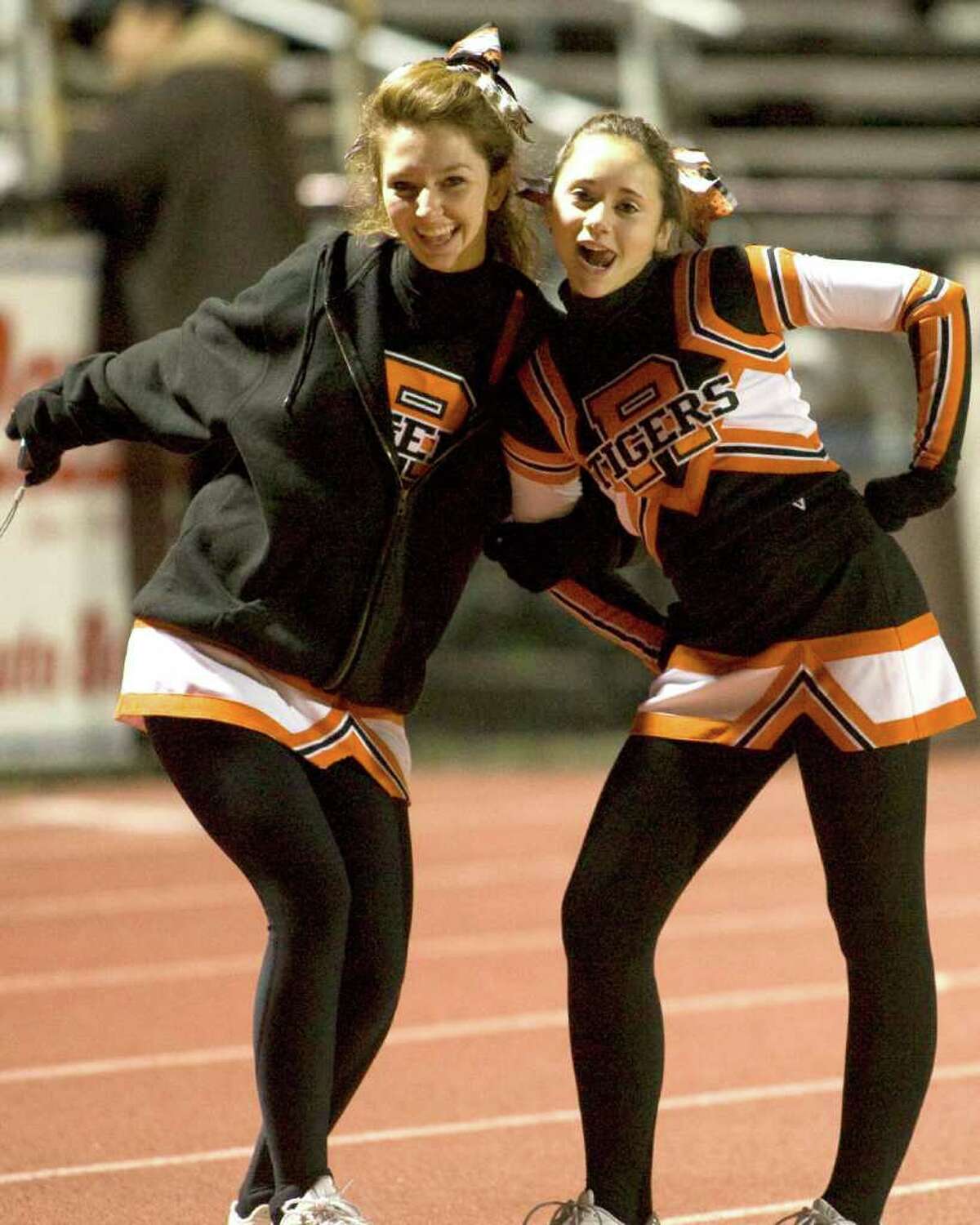 Two Ridgefield cheerleaders pose before the Tigers' football game against Trumbull Friday night, Nov. 5, 2010, at Ridgefield High School.