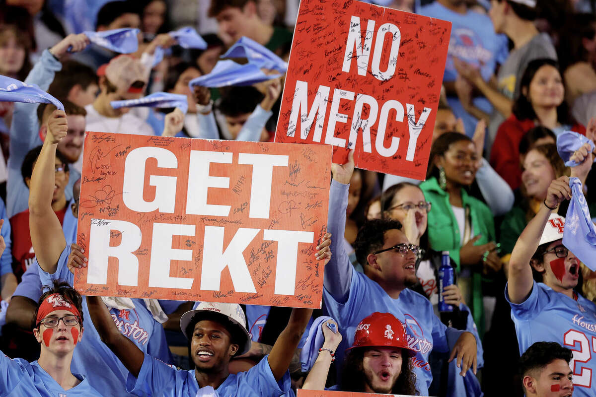 HOUSTON, TEXAS - NOVEMBER 23: Houston Cougars fans hold up signs during the first half against the Baylor Bears at TDECU Stadium on November 23, 2024 in Houston, Texas. (Photo by Alex Slitz/Getty Images)