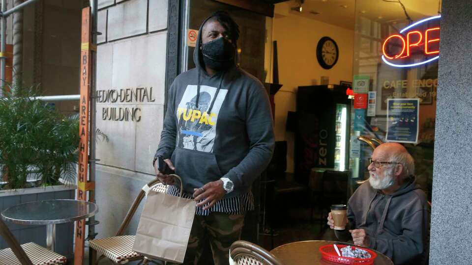 DoorDash driver Gleyson Coelho picks up an order for delivery at Cafe Encore on Post Street in San Francisco, Calif. on Wednesday, Nov. 4, 2020. California voters passed Prop. 22 which will allow drivers for ride-hail and delivery services to remain independent contractors for companies such as Uber, Lyft and DoorDash.