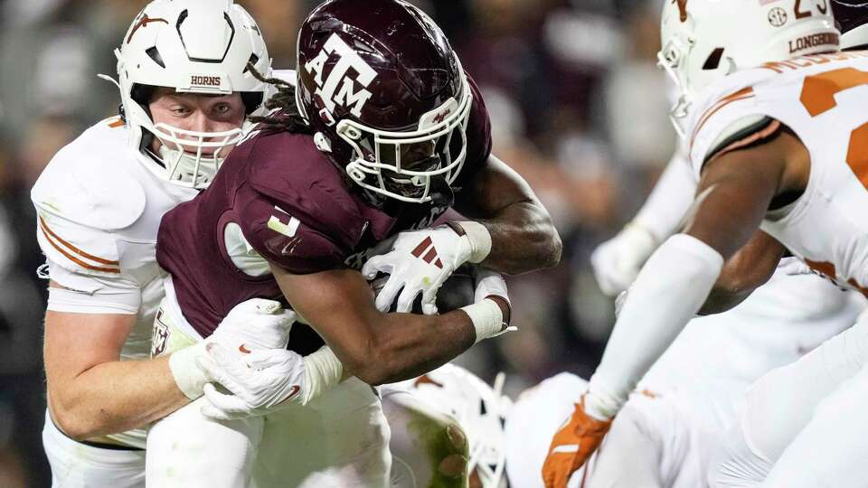 Texas linebacker Ethan Burke (91) stops Texas A&M running back Amari Daniels (5) for a loss on the goal line on fourth down during the second half of an NCAA college football game at Kyle Field, Saturday, Nov. 30, 2024, in College Station. Texas took over on downs after the play.