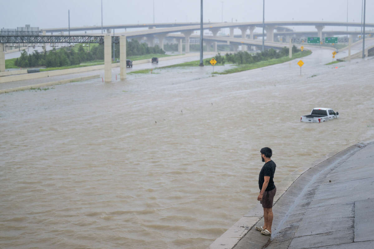 A person looks out towards the flooded interstate after Hurricane Beryl swept through the area on July 08, 2024, in Houston, Texas. 