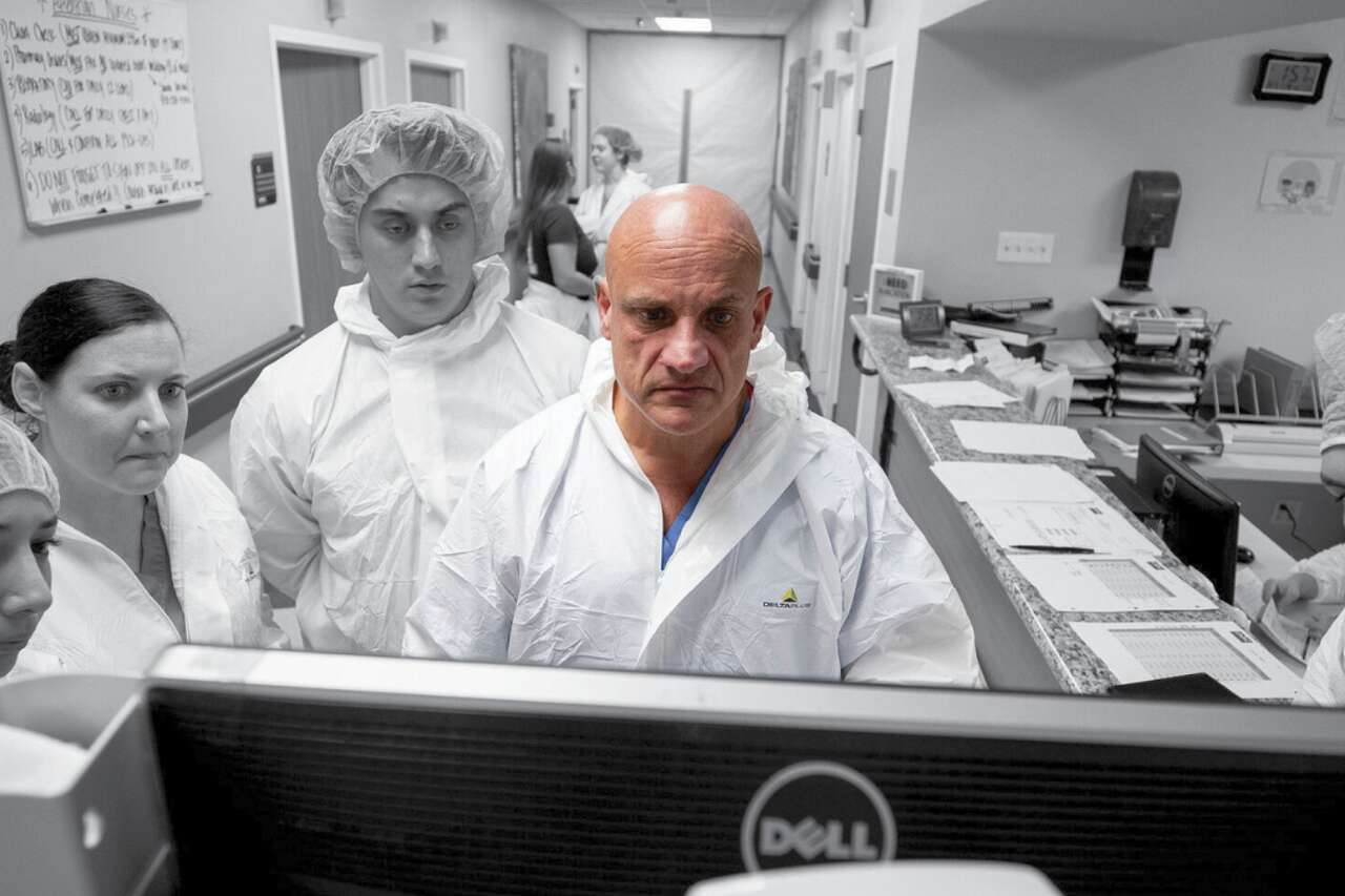 Dr. Joseph Varon, center, reviews patient's CT scans with physicians and nurses after concluding rounds in UMMC's COVID-19 intensive care unit Tuesday, April 28, 2020, in Houston.