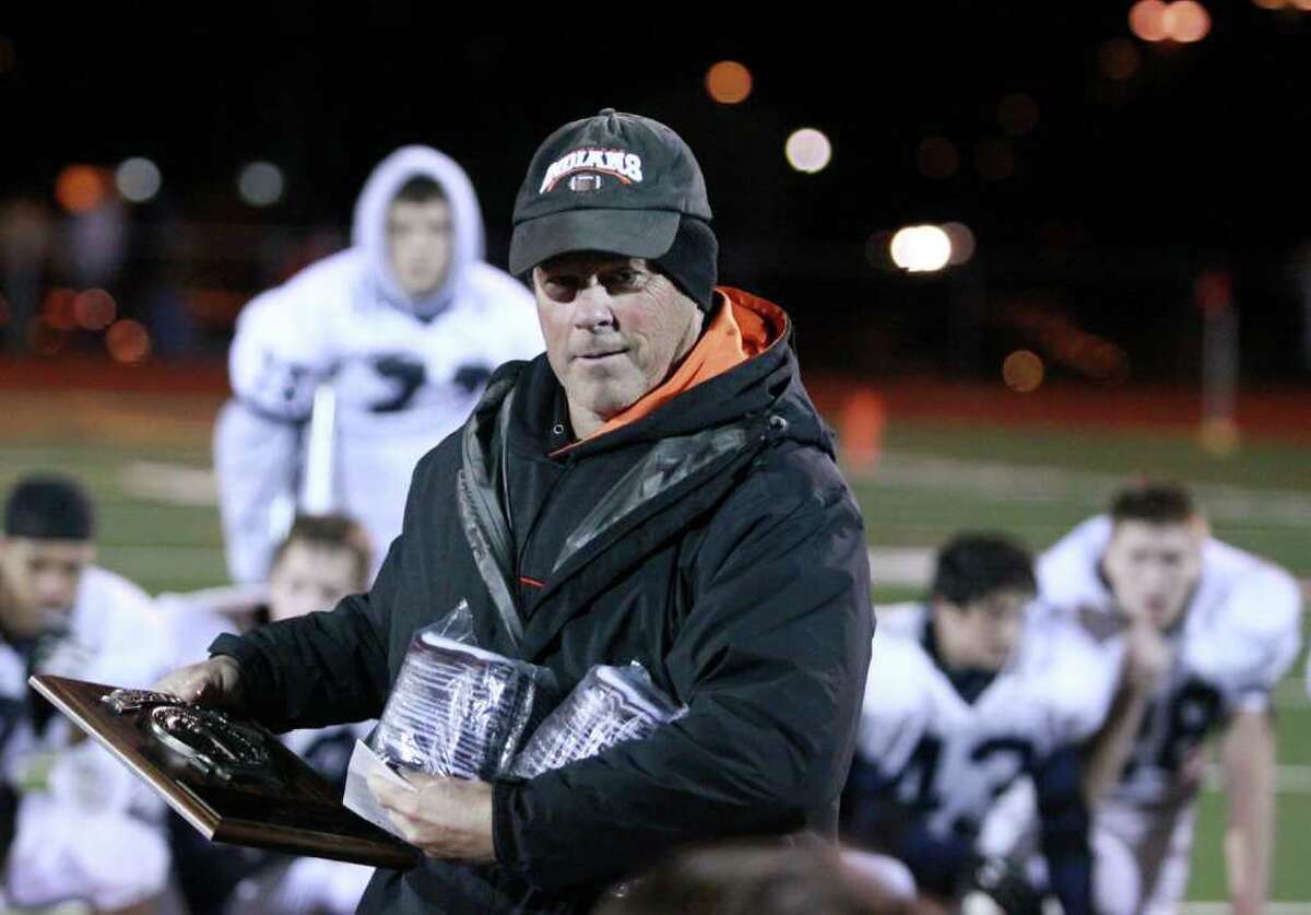 HIGH SCHOOL FOOTBALL - Cambridge head coach Doug Luke looks at the plaque after his team won the Class D Super Bowl against Rensselaer at Schuylerville High School. (Patrick Dodson / Special to the Times Union)