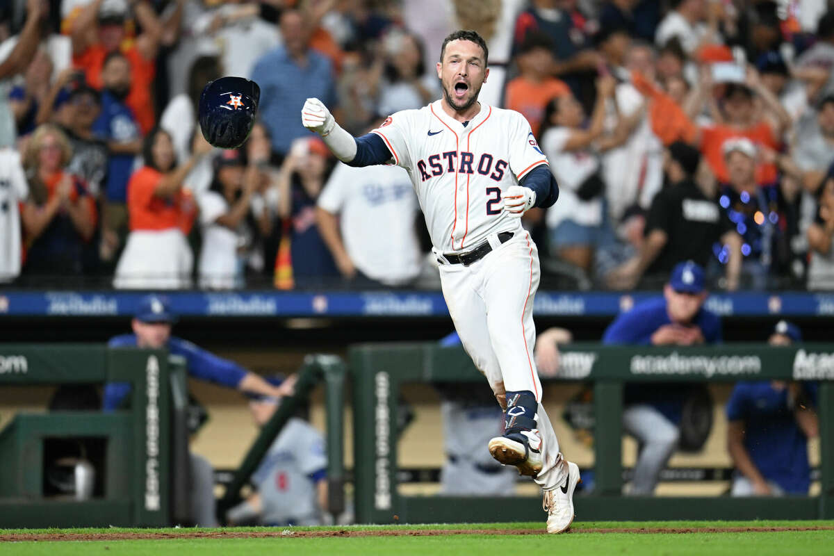 HOUSTON, TEXAS - JULY 27: Alex Bregman #2 of the Houston Astros tosses his helmet and celebrates after hitting the game-winning home run in the ninth inning beating the Los Angeles Dodgers by a score of 7-6 at Minute Maid Park on July 27, 2024 in Houston, Texas. (Photo by Jack Gorman/Getty Images)