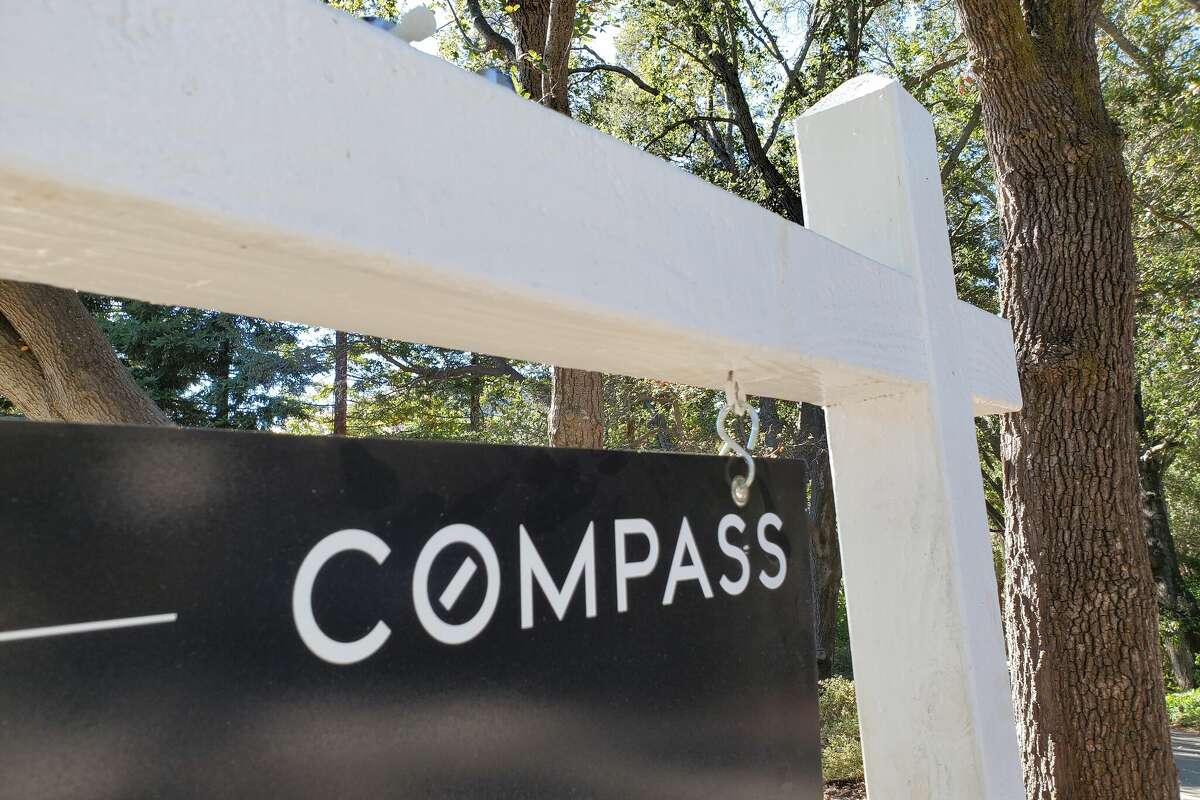 Close-up of a Compass Real Estate hanging sign panel in a wooded area, Lafayette, California, October 21, 2020. (Photo by Smith Collection/Gado/Getty Images)