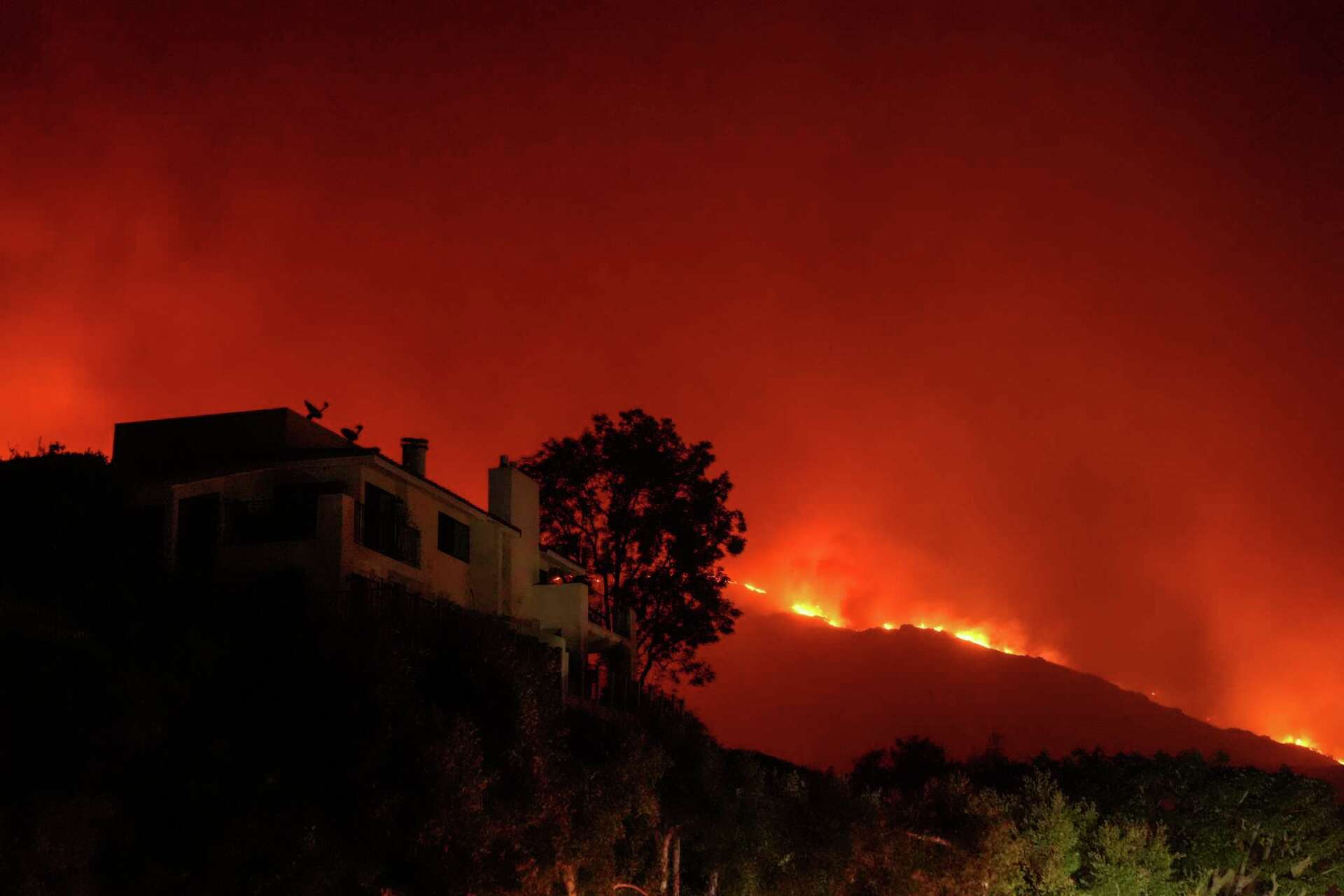 A three-alarm brushfire burns in Malibu, prompting mandatory evacuations