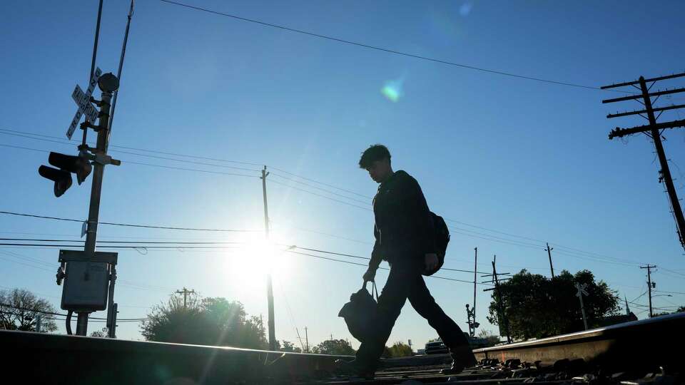 A Milby High School student crossing the train track to go to school Wednesday, Dec. 11, 2024 at Milby High School in Houston. A 15-year-old student was struck and killed by a train while on the tracks Monday morning.