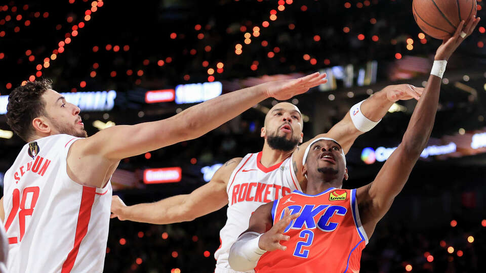Oklahoma City Thunder guard Shai Gilgeous-Alexander (2) shoots against Houston Rockets center Alperen Sengun (28) and forward Dillon Brooks, back right, during the first half of a semifinal game in the NBA Cup basketball tournament Saturday, Dec. 14, 2024, in Las Vegas. (AP Photo/Ian Maule)