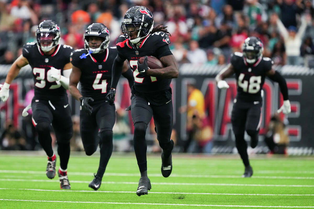 Houston Texans safety Calen Bullock (21) returns the ball after intercepting a pass by Miami Dolphins quarterback Tua Tagovailoa during the first half of an NFL football game, Sunday, Dec. 15, 2024, in Houston.