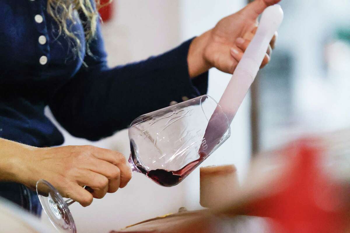 Winemaker Britt Richards use a wine thief to siphon wine from a barrel while conducting barrel tasting at Laird Winery on Monday, December 9, 2024 in Napa, Calif.