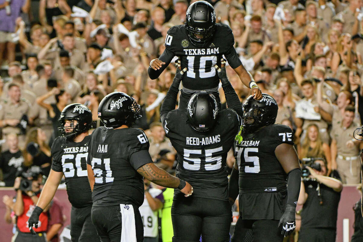 COLLEGE STATION, TX - OCTOBER 26: Texas A&M Aggies offensive lineman Ar'maj Reed-Adams (55) hoists Texas A&M Aggies quarterback Marcel Reed (10) high over his head after his second half rushing touchdown during the football game between the LSU Tigers and Texas A&M Aggies on October 26, 2024 at Kyle Field in College Station, Texas. (Photo by Ken Murray/Icon Sportswire via Getty Images)