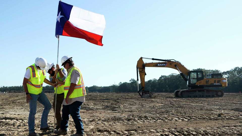 Workers install a Texas flag near a groundbreaking for Northport Logistics’s new 1.2 million square-foot facility in Conroe Park North, Wednesday, Sept. 14, 2022, in Conroe. Once completed, the completed will be the largest in the city’s industrial park park to date.