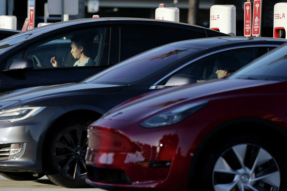 Drivers wait as their Tesla electric vehicles (EVs) recharge at a Tesla Supercharger station on September 23, 2024 in Pasadena, California. 