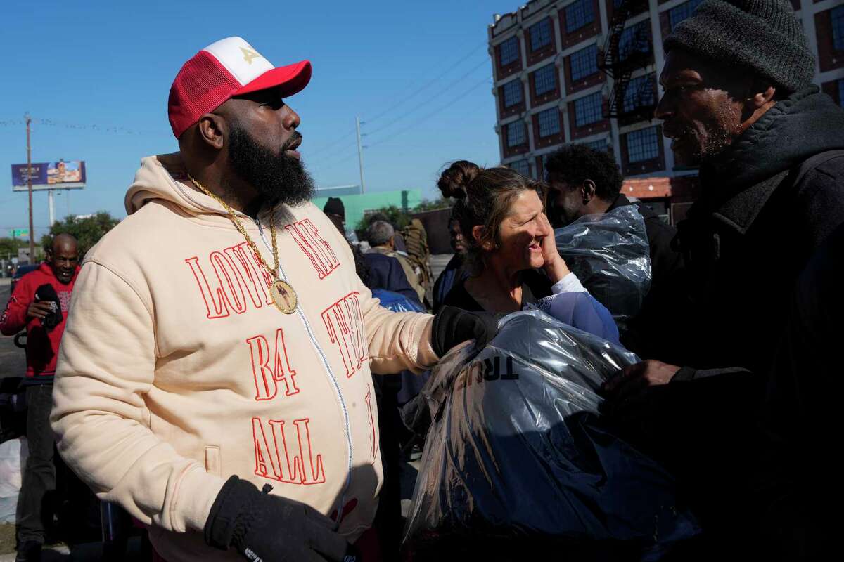 Rapper Trae tha Truth, left, and members of his philanthropy organizations Angel by Nature and Relief Gang giving away jackets to homeless people Sunday, Dec. 22, 2024 at East Downtown in Houston. The rapper was giving away 150 jackets, beverages, snack and hot food to homeless people in need.