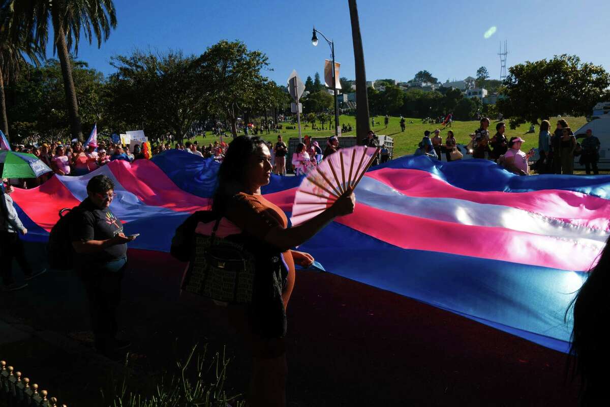 Antonella Delgado helps hold up a large transgender pride flag at the beginning of the Trans March from Dolores Park to Turk and Taylor streets in downtown San Francisco on Friday, June 28, 2024.