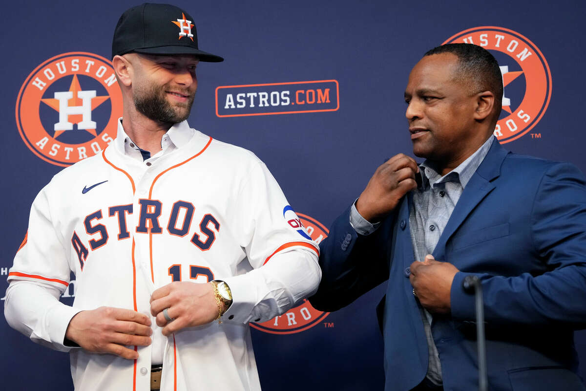 Houston Astros new player Christian Walker jokingly says that General Manager Dana Brown is making him nervous while helping him to put on his Astros jersey during a press conference Monday, Dec. 23, 2024 at Minute Maid Park in Houston.