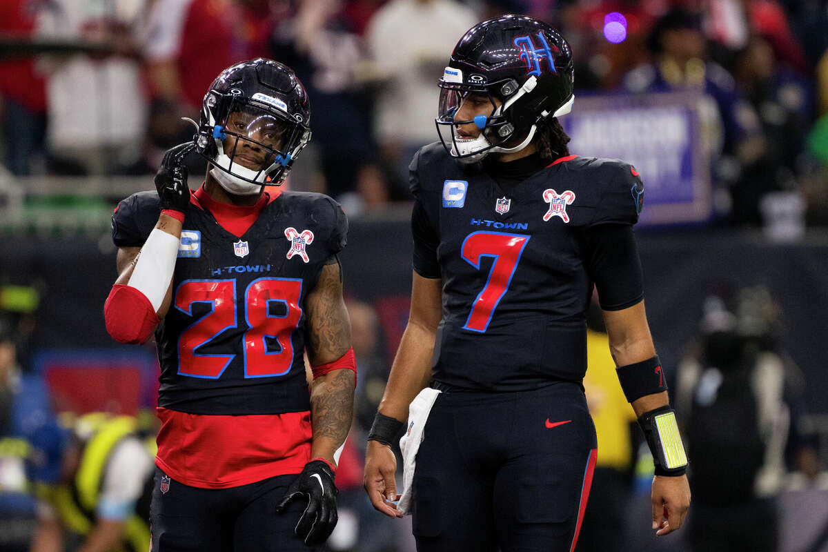 Houston Texans quarterback C.J. Stroud, right, visits with running back Joe Mixon after Mixon came up short on fourth down, one yard from the goal line during the first half of an NFL football game, Wednesday, Dec. 25, 2024, in Houston.