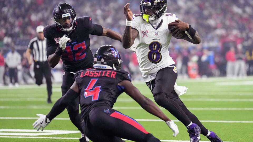 Baltimore Ravens quarterback Lamar Jackson (8) runs the ball between Houston Texans defensive end Dylan Horton (92) and cornerback Kamari Lassiter (4) during the second half of an NFL football game Wednesday, Dec. 25, 2024, in Houston.