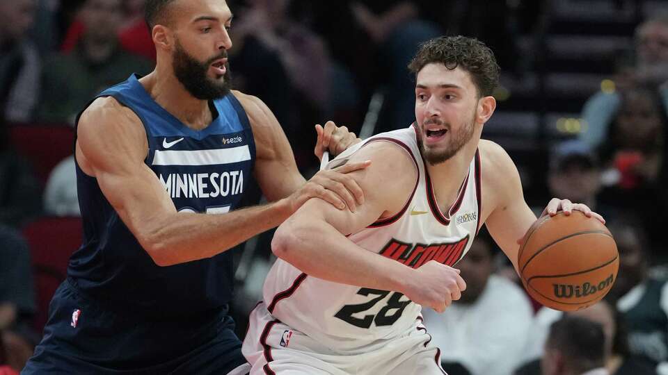 Houston Rockets center Alperen Sengun (28) drives the baseline against Minnesota Timberwolves center Rudy Gobert (27) during the first quarter of game action at the Toyota Center on Friday, Dec. 27, 2024 in Houston.